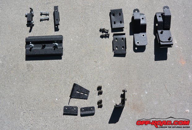 Here is the supplied hardware supplied by SmittyBilt to install are Defender Roof Rack on our WJ Build. The install kit includes roof mounting hardware (bottom pieces, Part# S/BDS2-6), Shovel and Axe mounts (top left, Part# D-8138) and a Trail Jack mount (top right, Part# D-8076).