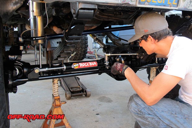 Esteban Hernandez, owner and builder of Project Retro F-350, tightens up the bolts attached to the axle housing tabs and the AGR Rock Ram before adding hydraulic hoses.
