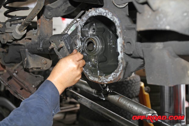 With the front diff cover off, a razor blade is used to scrape off the original gasket material. 