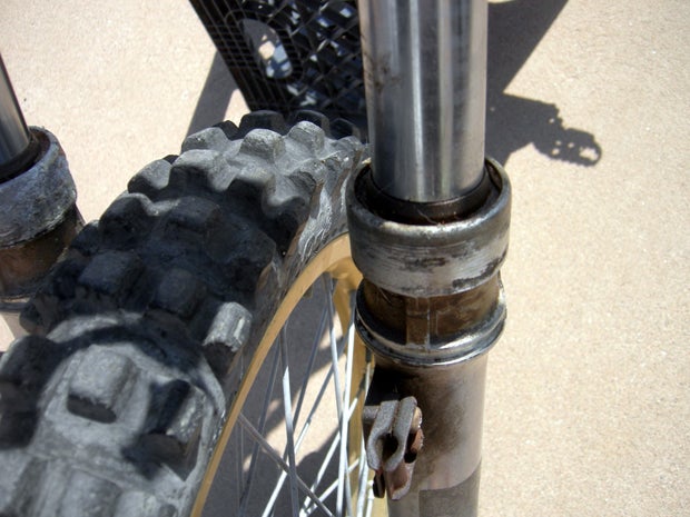Check the forks closely for rust, dents or scratches. While you're at it, give a close inspection to the area where the fork seals reside. If there is a bunch of dried up crud and oil around the seals, you've got problems.