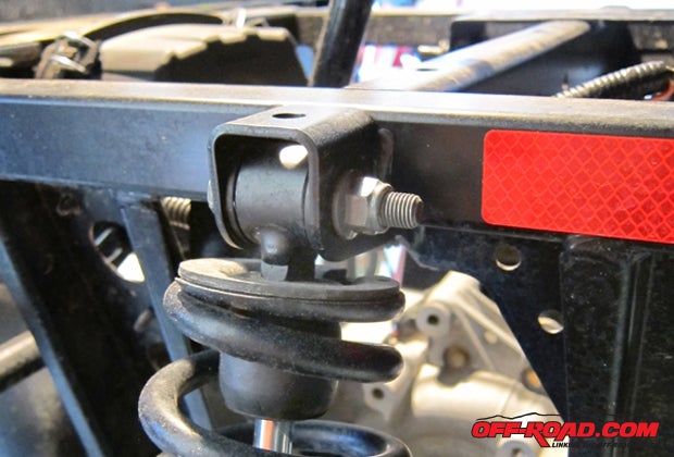 The rear shock is unbolted from the frame and the bracket is laid over the frame and shock mount.